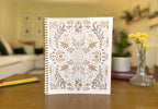 Notebook with decorative cover featuring the word 'Peace' on a blurred indoor background