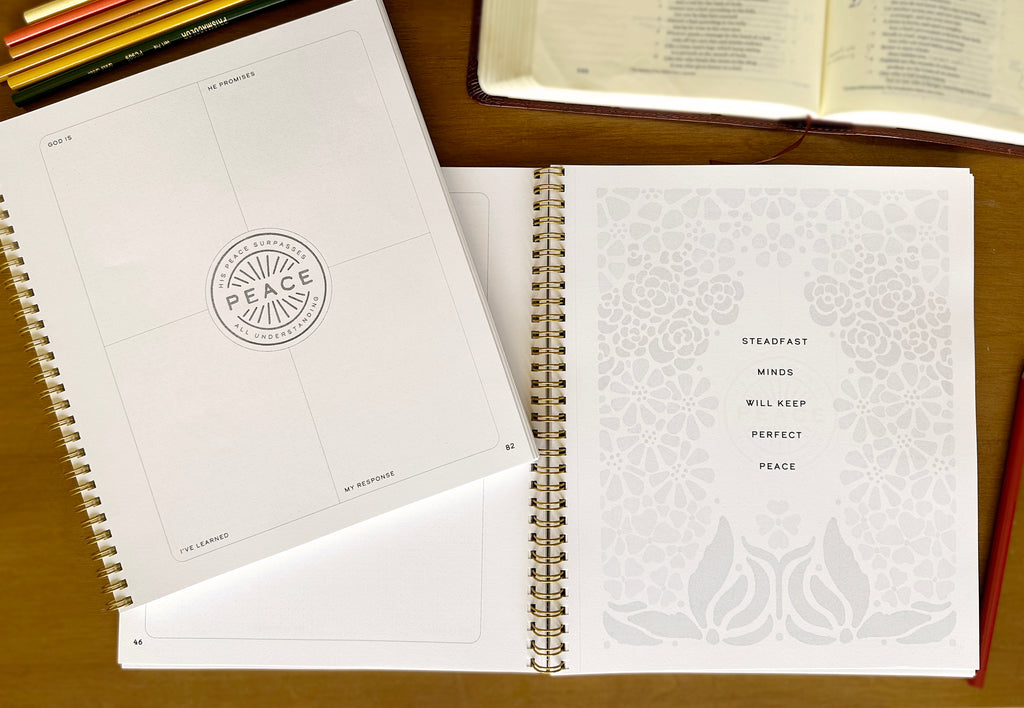 Open spiral-bound notebook with text and design on a wooden surface