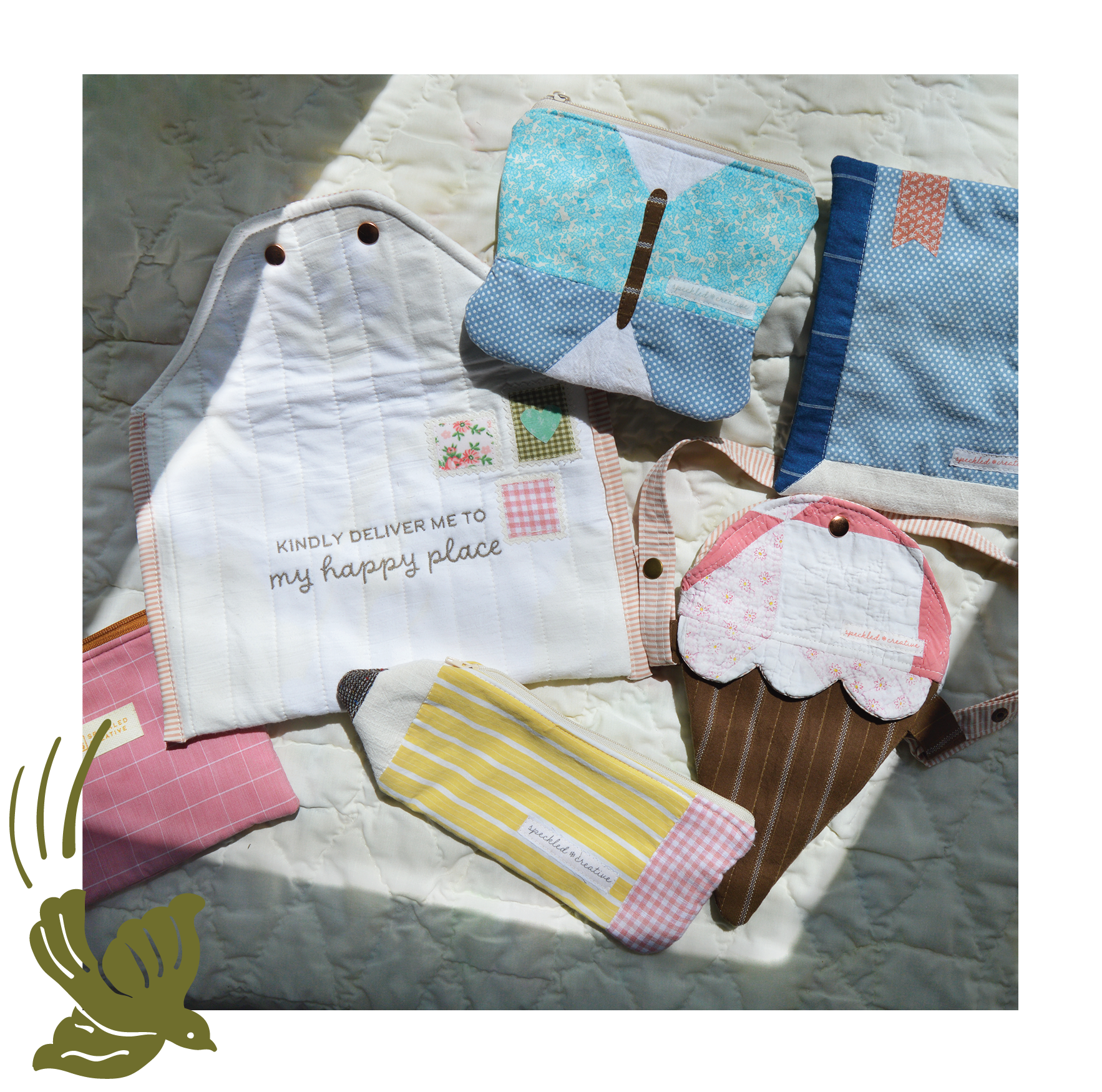 Collection of colorful pouches laid out of a white quilted surface