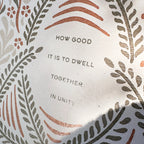 Decorative plate with floral patterns and text 'HOW GOOD IT IS TO Dwell TOGETHER IN UNITY' on a white background.