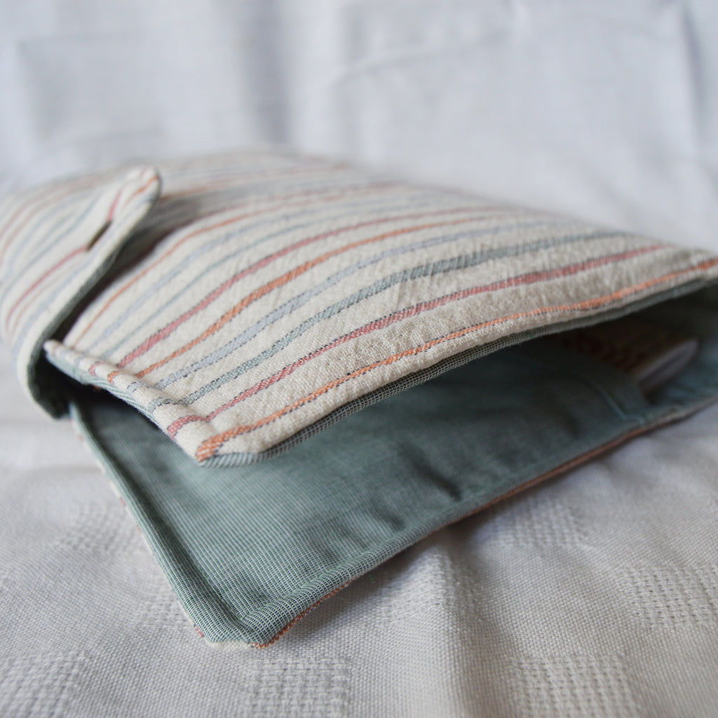 Folded fabric pouch with striped pattern on a textured surface