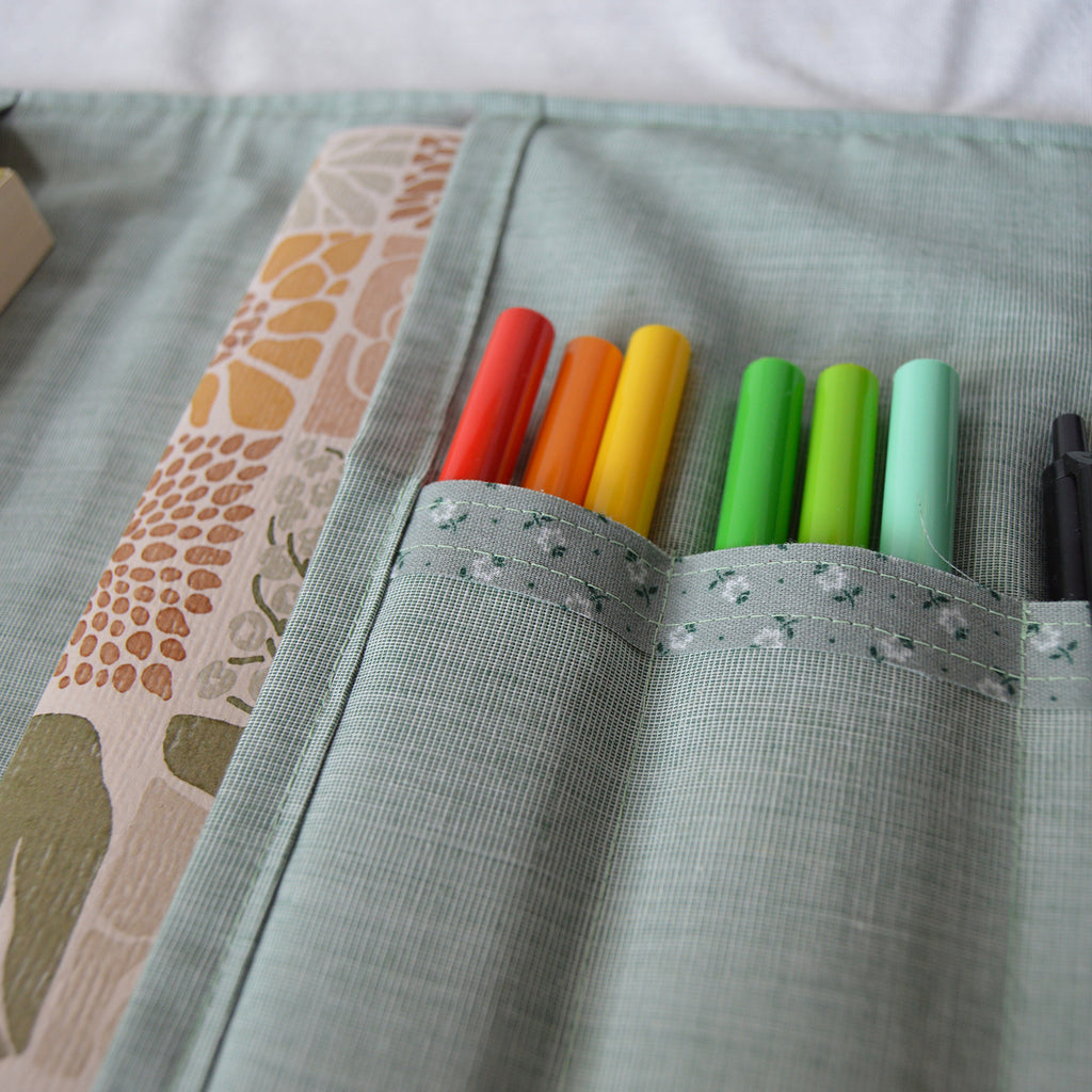 Colorful markers in slots in a fabric pouch