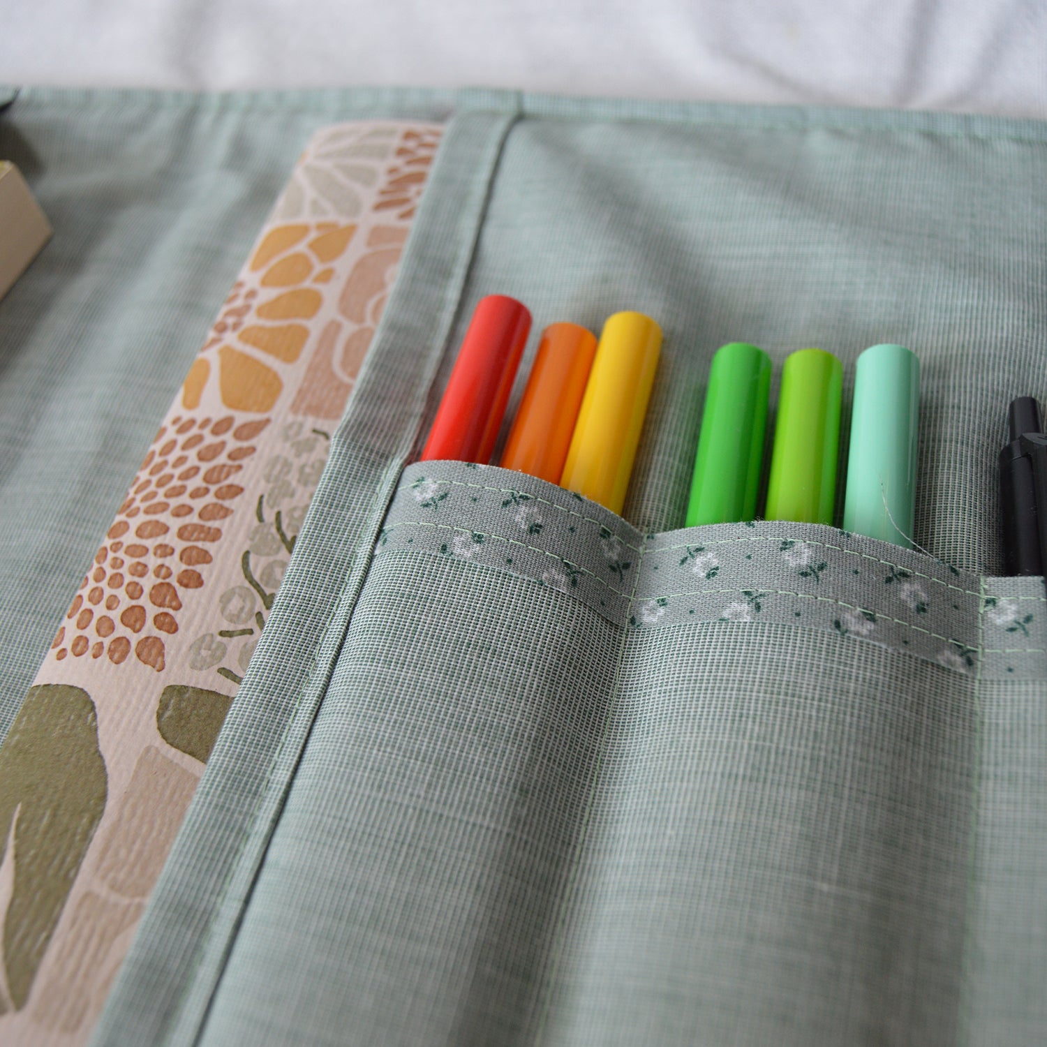 Colorful markers in slots in a fabric pouch
