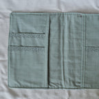 Interior teal fabric pouch with floral accents on a white background