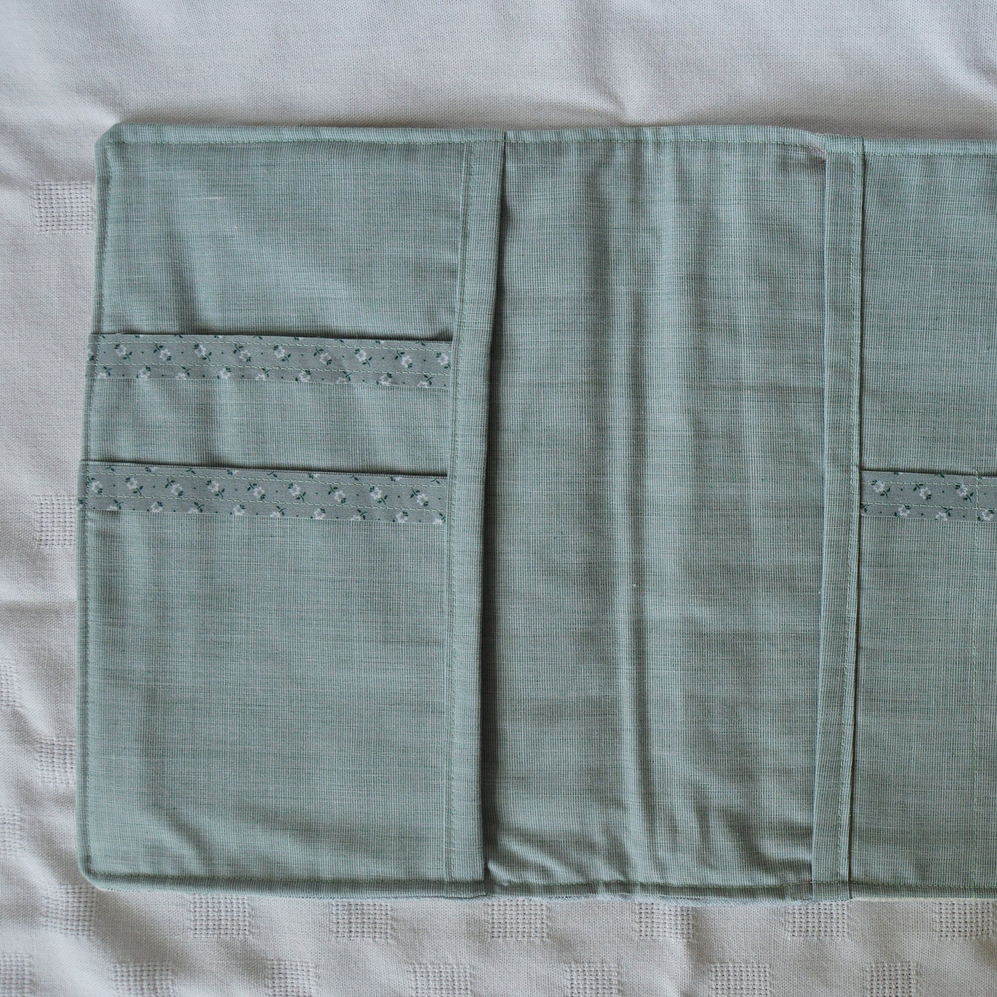 Interior teal fabric pouch with floral accents on a white background