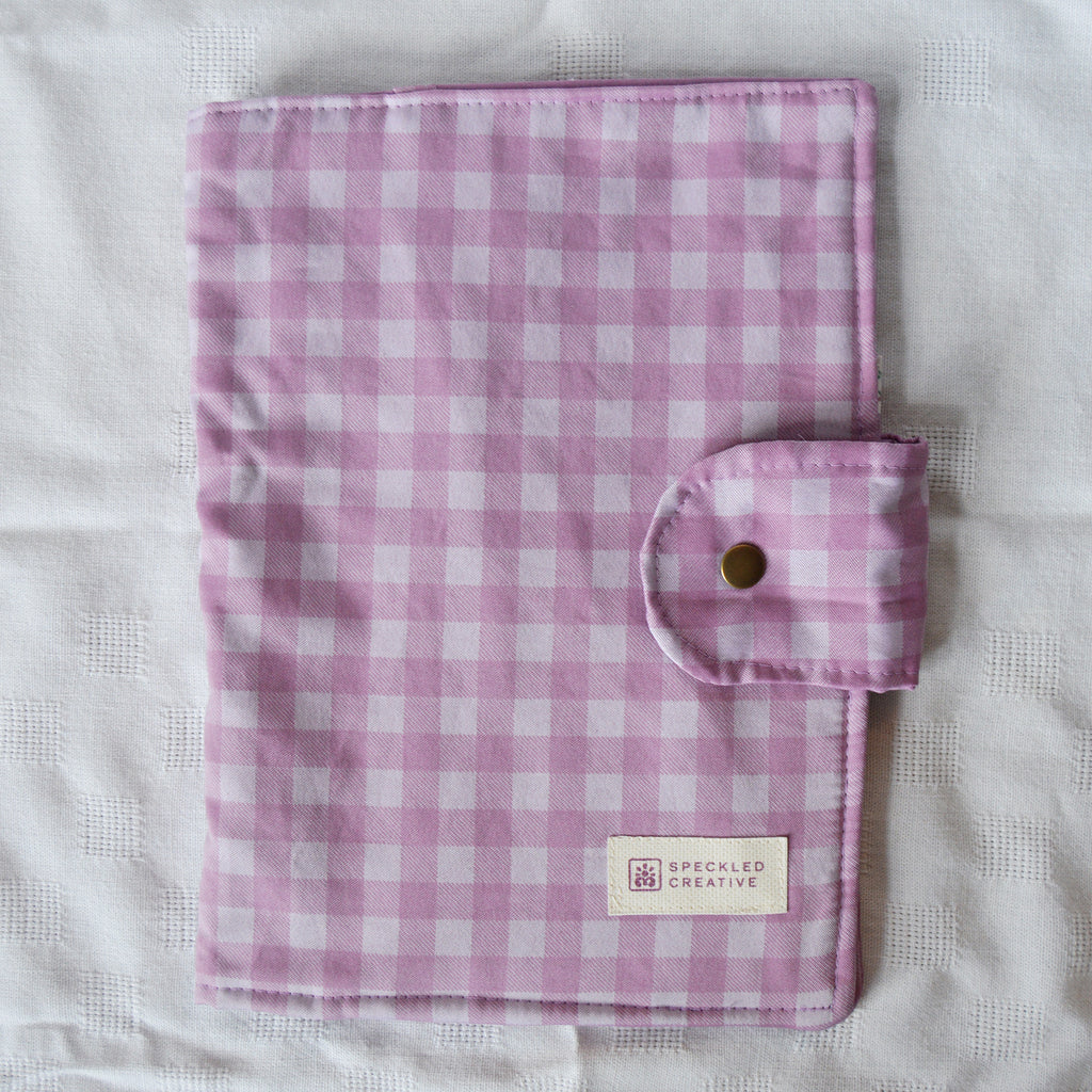 Purple and white checkered fabric with a button and Speckled Creative label on a white background