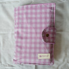 Purple checkered fabric pouch with a brand label on a light background