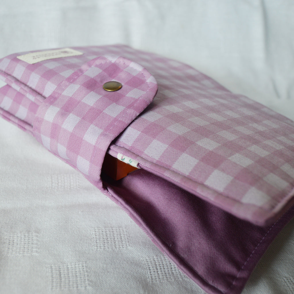 Purple checkered pouch with a button on a white background