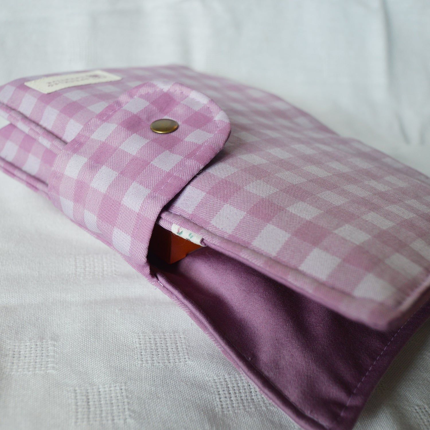 Purple checkered pouch with a button on a white background