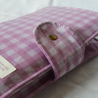 Purple checkered fabric pouch with a button on a white background