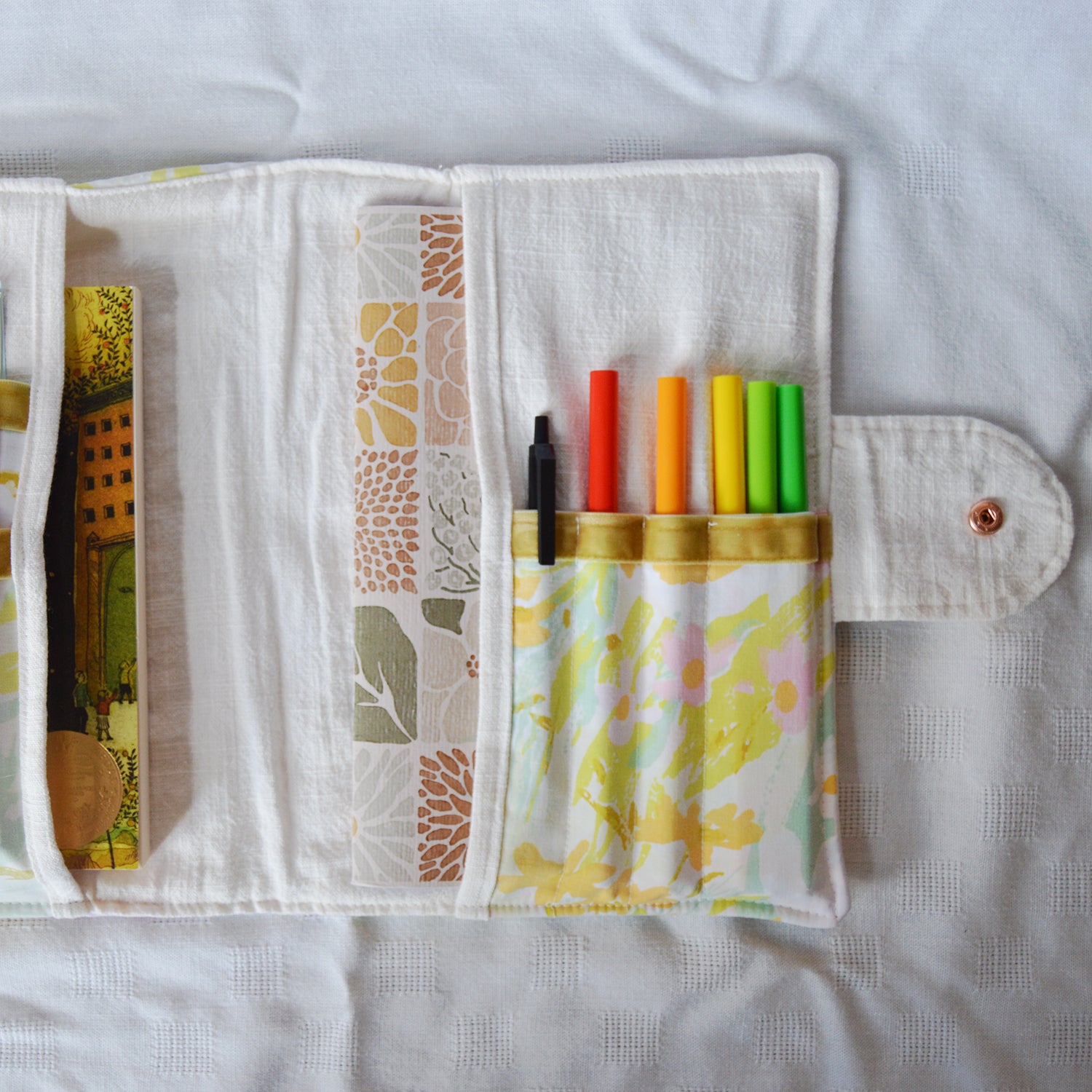 Fabric pouch with slots for colorful pens  on a light background
