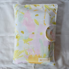 Floral patterned pouch with a brand label on a light background