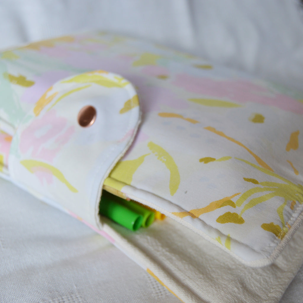 Folded fabric pouch with floral pattern on a white background