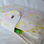 Folded fabric pouch with floral pattern on a white background