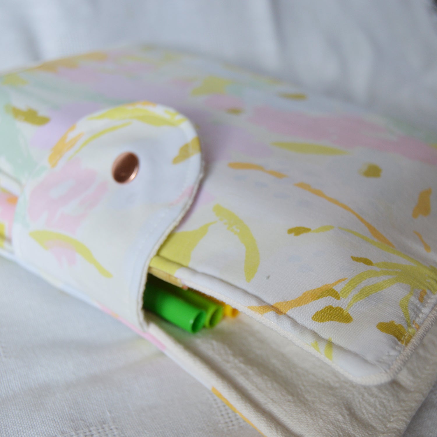 Folded fabric pouch with floral pattern on a white background