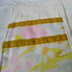 Floral-patterned fabric with a yellow border on a light background
