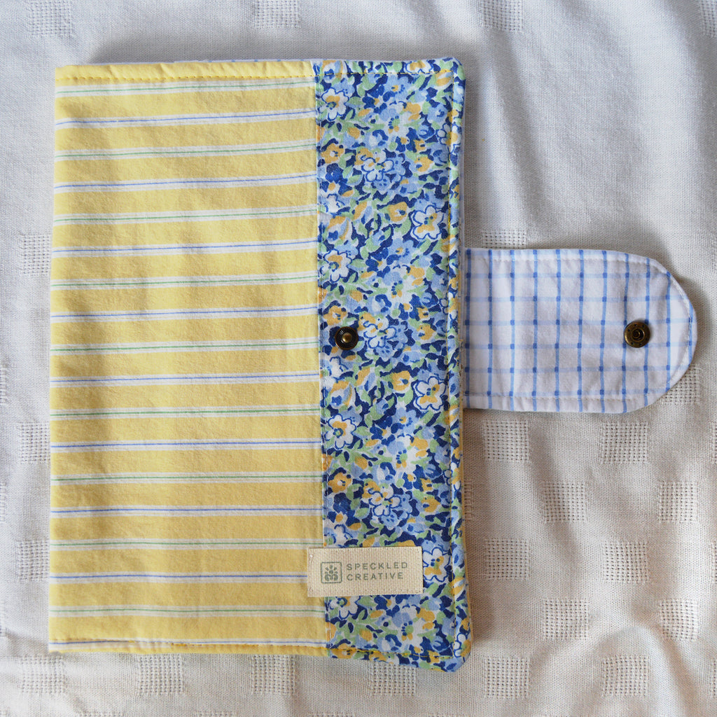 Yellow striped pouch with a floral border on a textured surface