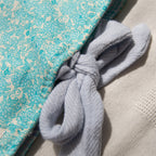 Close up on a light blue linen tie closure for a blue floral e-reader sleeve