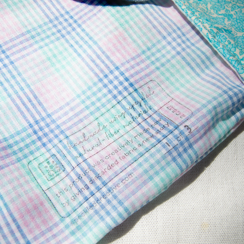 Close-up of a checkered fabric with a label on a light background