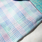 Close-up of a checkered fabric with a label on a light background