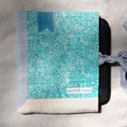 E-reader sleeve with blue and white patterned and a blue bookmark appliqué on a gray surface