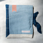 E-reader sleeve with blue and white polka dot pattern, tie closure, and red bookmark appliqué
