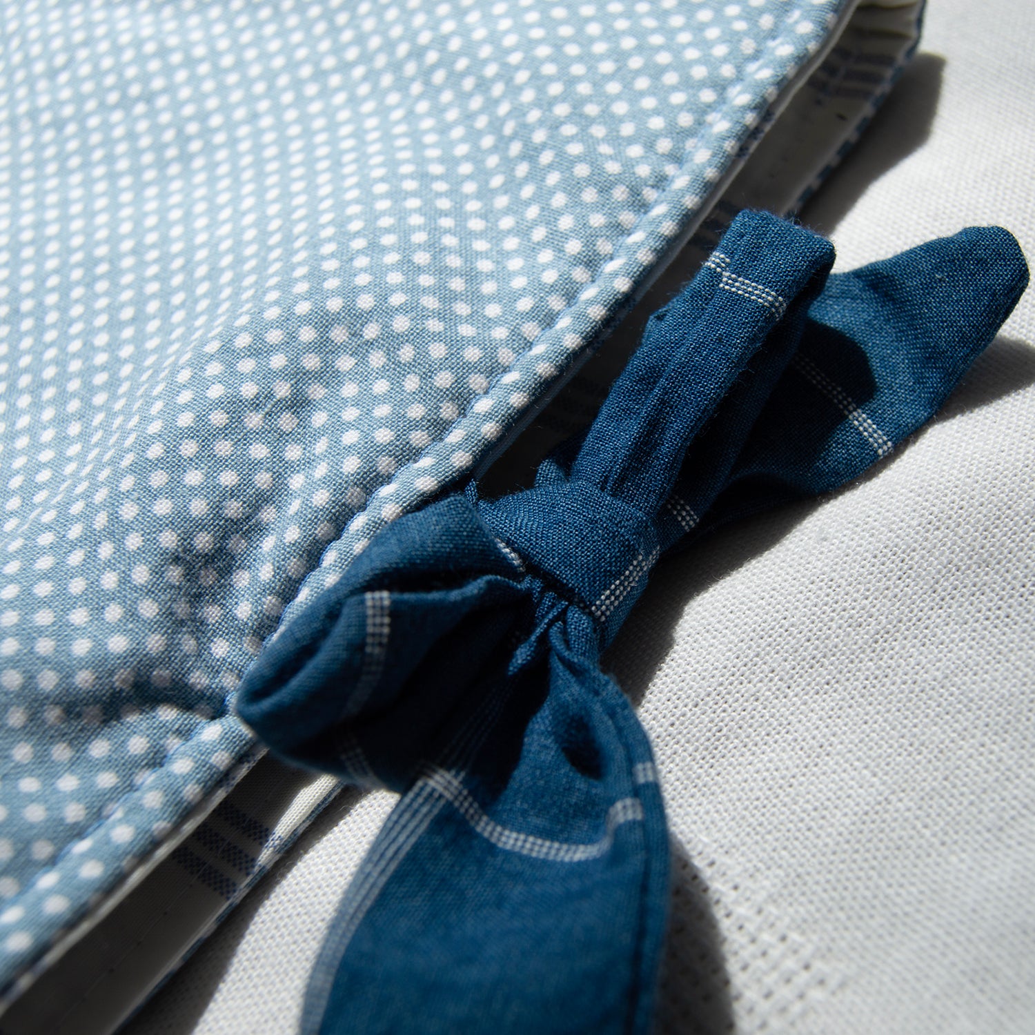 Close up of tie closure on a e-reader sleeves that is blue polka dot fabric with a blue bow