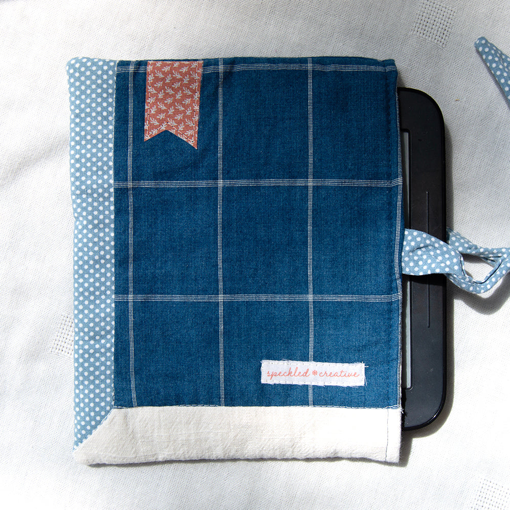Blue checkered e-reader pouch with polka dot accents on a white background