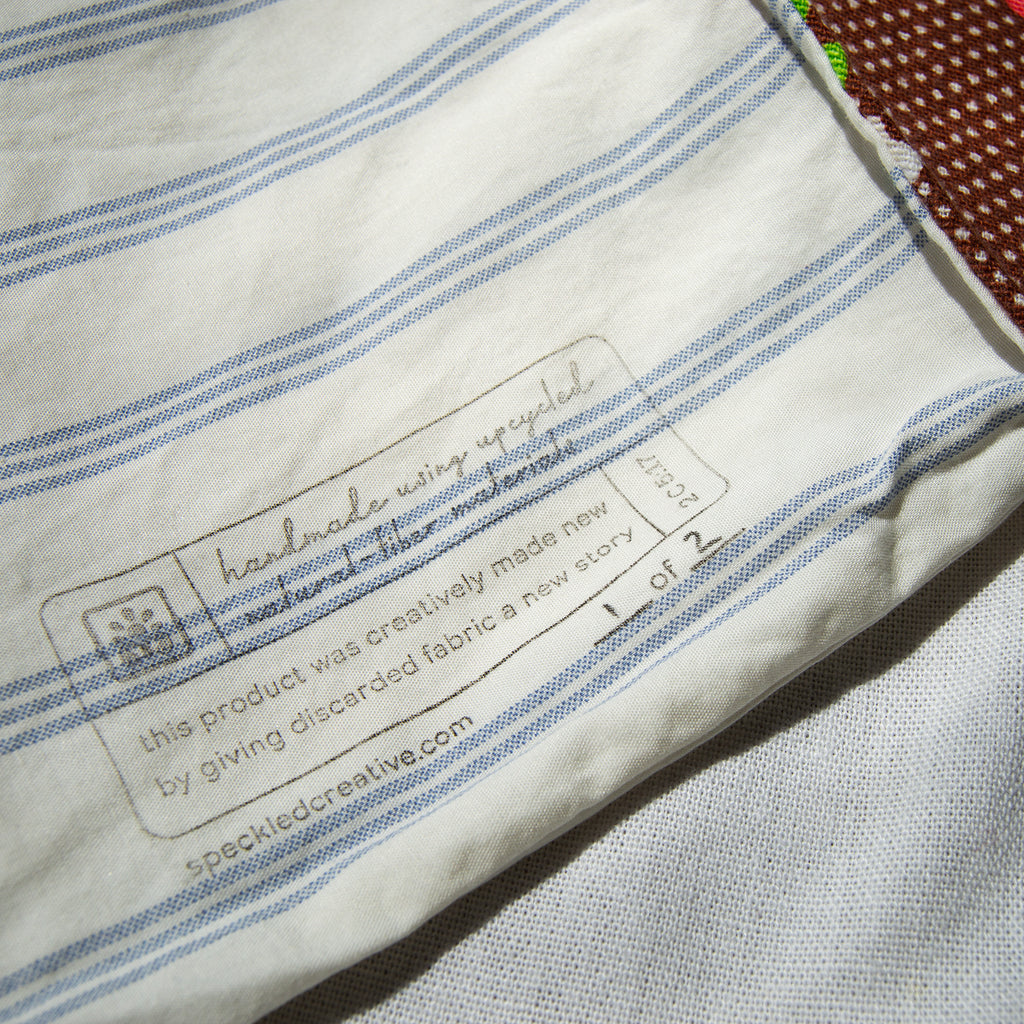 Label on a piece of fabric with blue stripes, featuring text about recycled product.