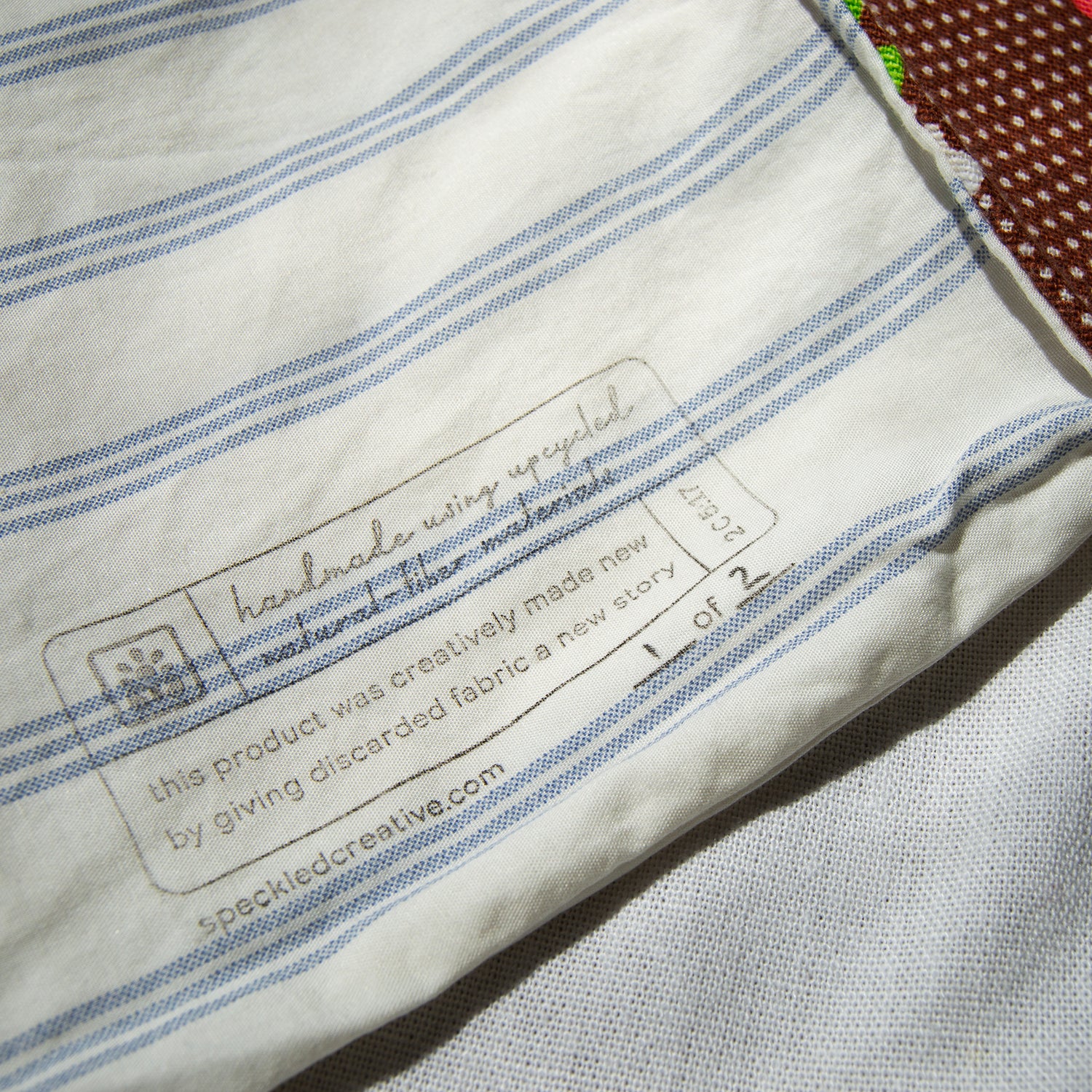 Label on a piece of fabric with blue stripes, featuring text about recycled product.