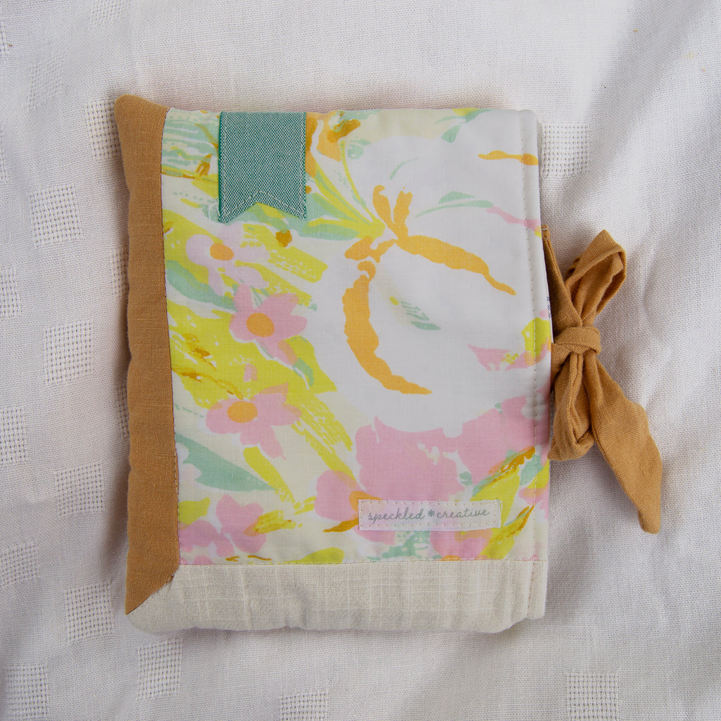 Floral patterned e-reader pouch with a bow on a light background