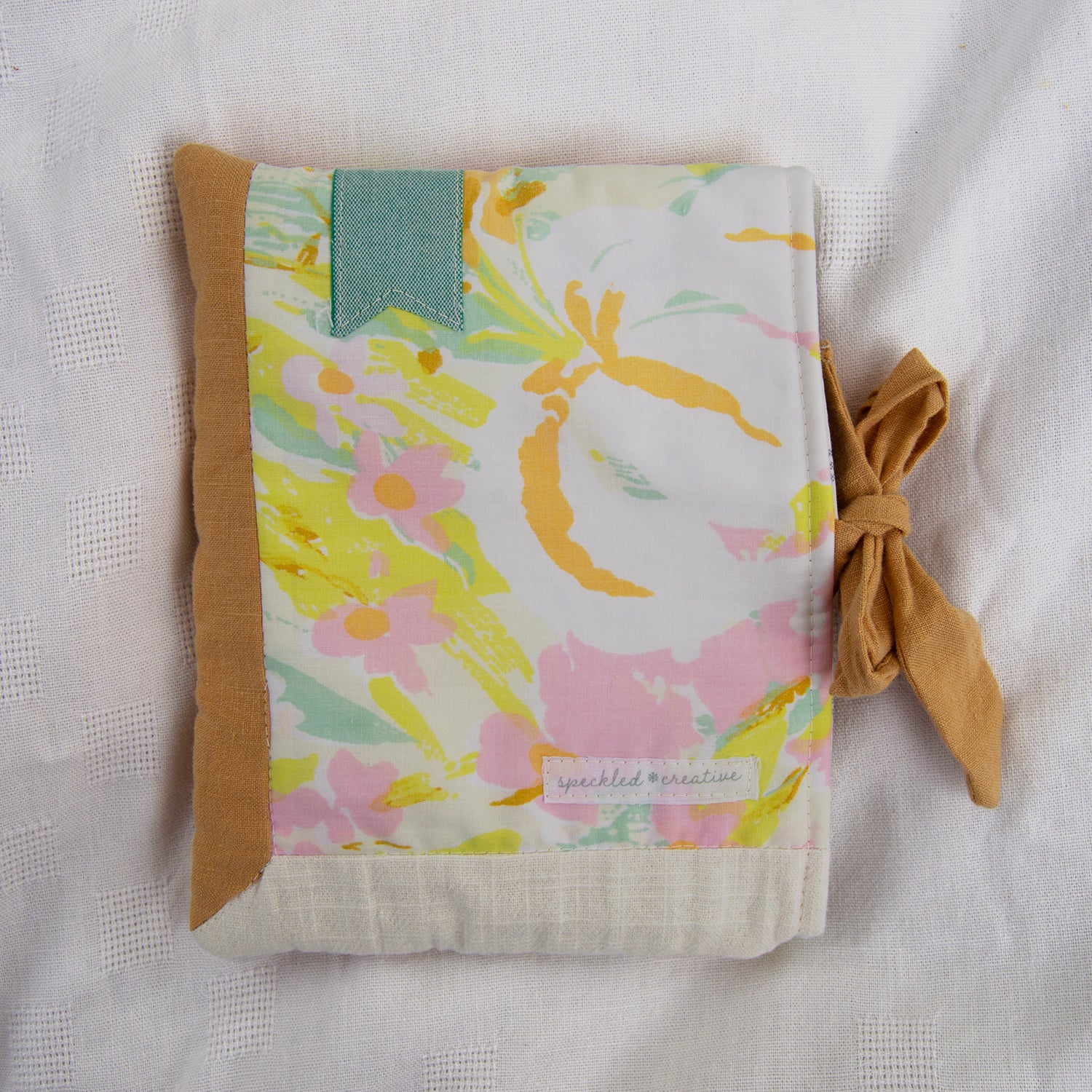 Floral patterned e-reader pouch with a bow on a light background