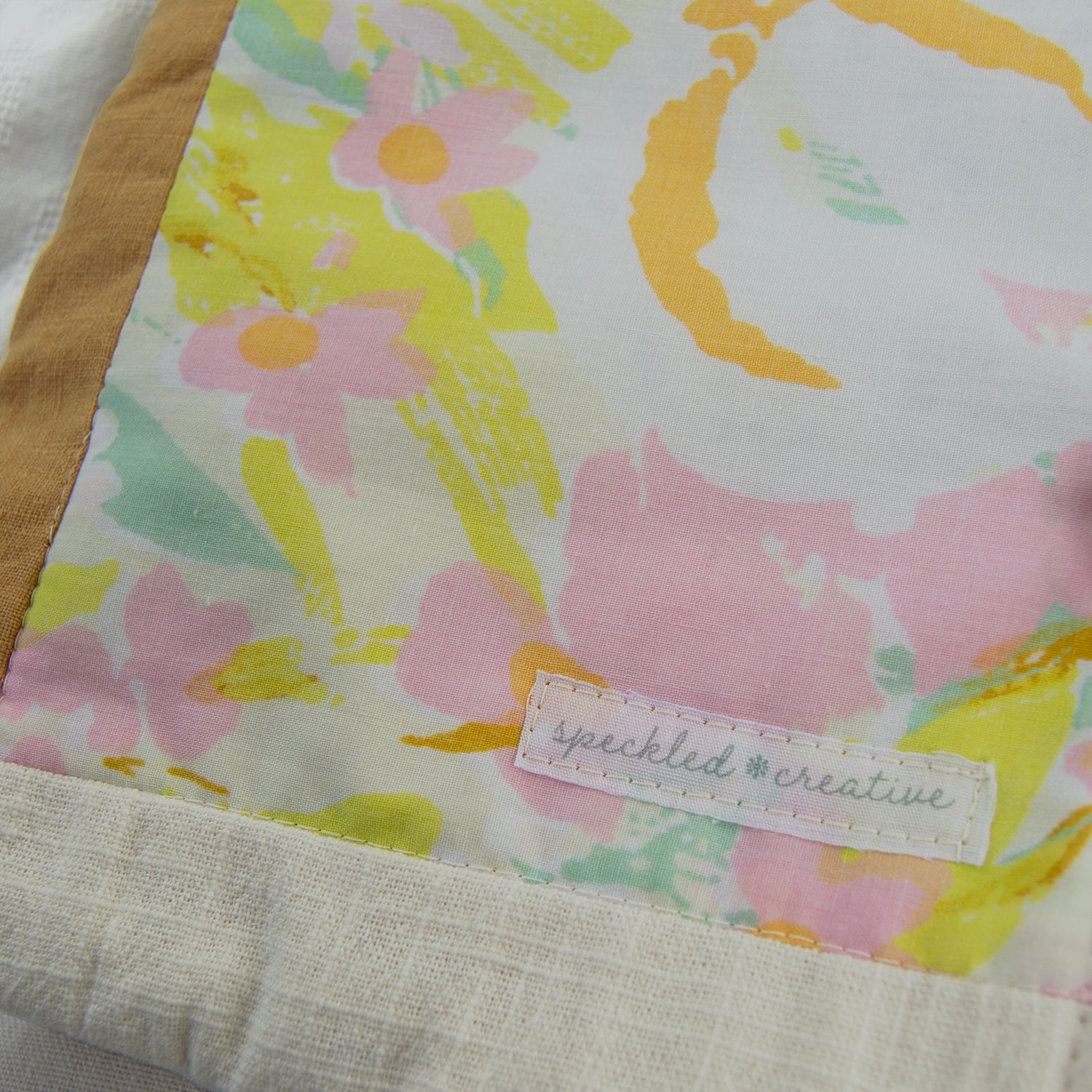 Floral patterned fabric e-reader sleeve with a 'speckled creative' label