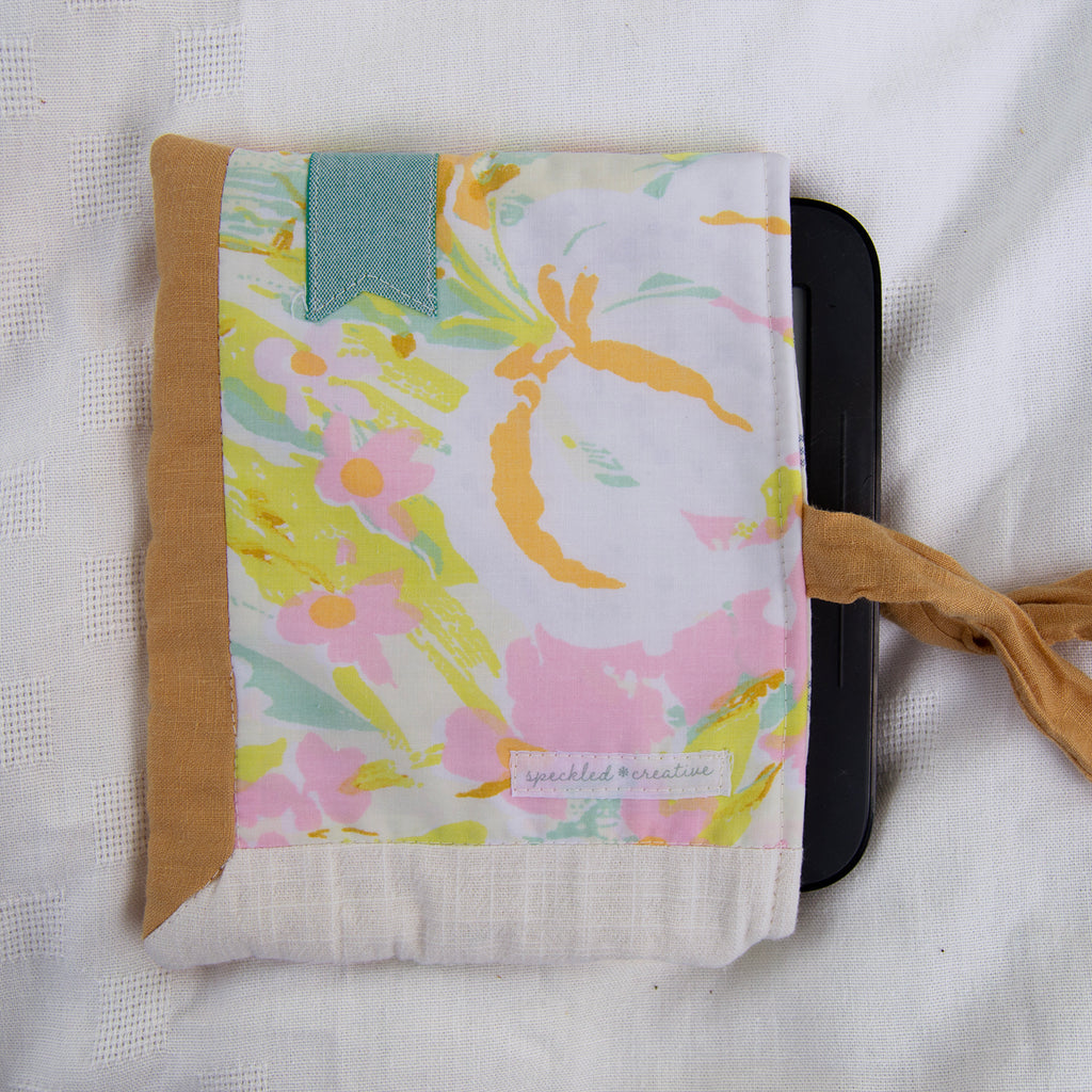 Floral patterned pouch with a brown border on a white background