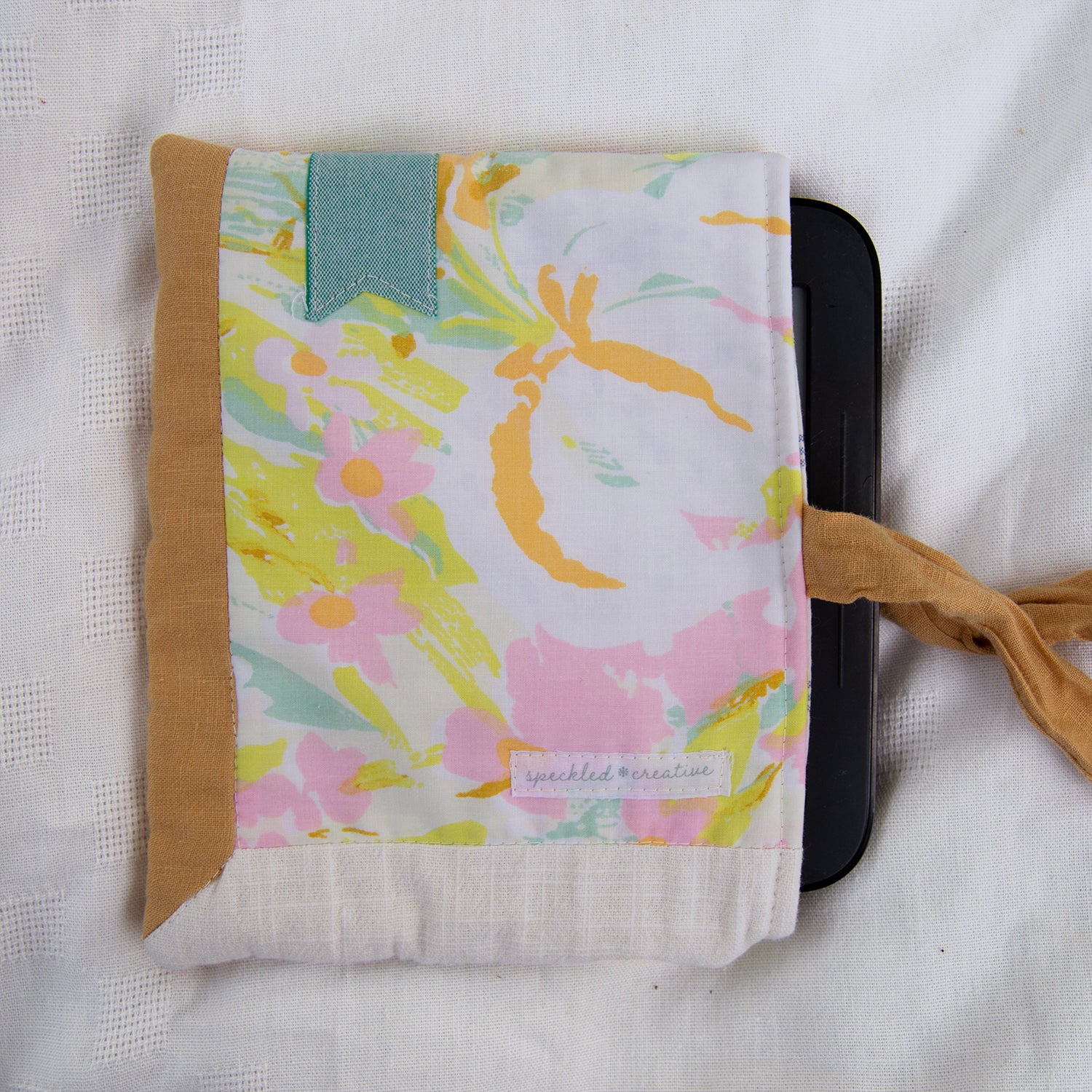Floral patterned pouch with a brown border on a white background