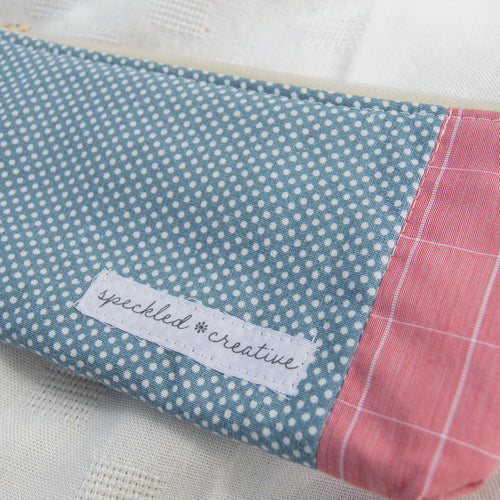 Close-up of a fabric product shaped like a pencil with a 'speckled creative' label on a white background