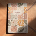 Notebook with floral pattern on a wooden surface