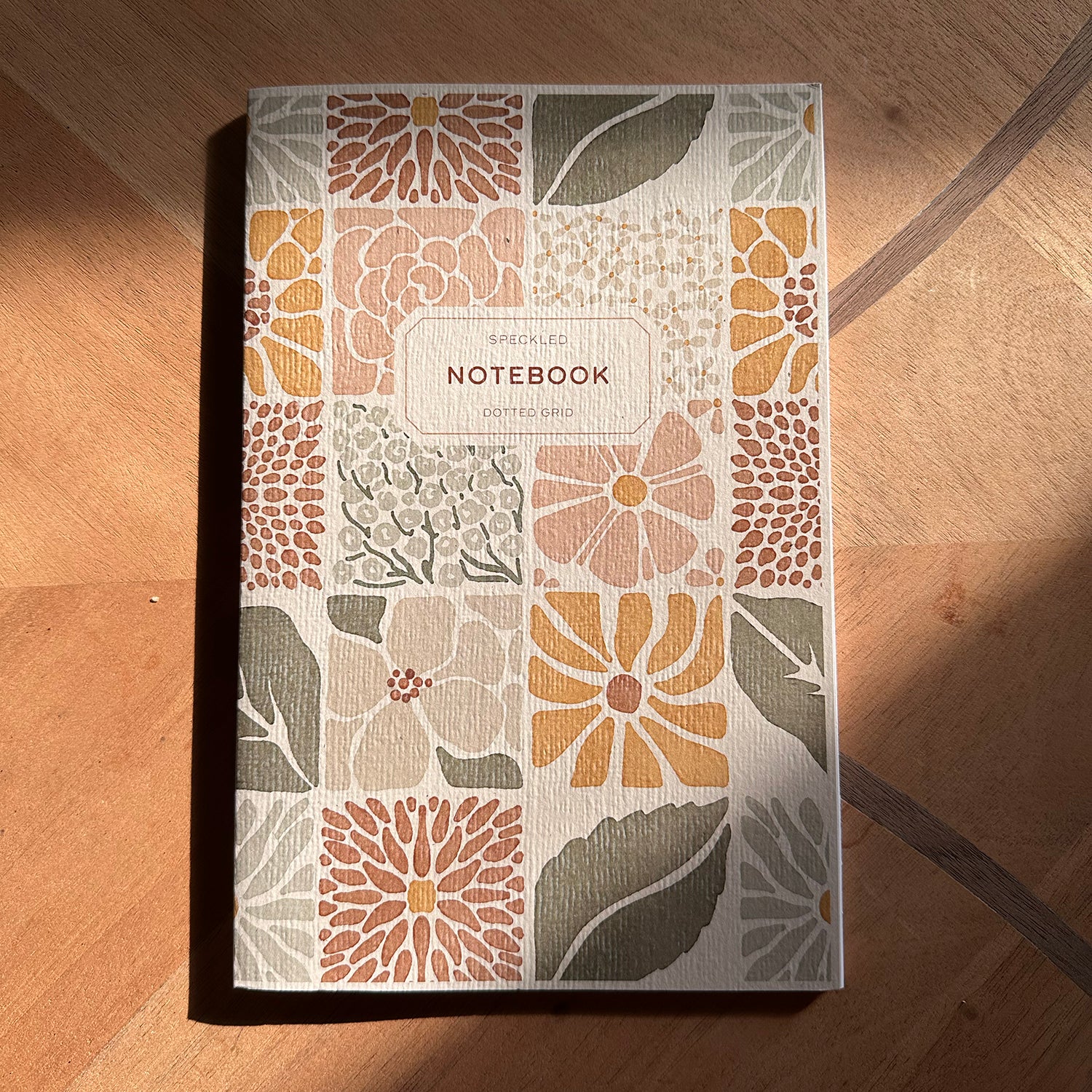 Notebook with floral pattern on a wooden surface