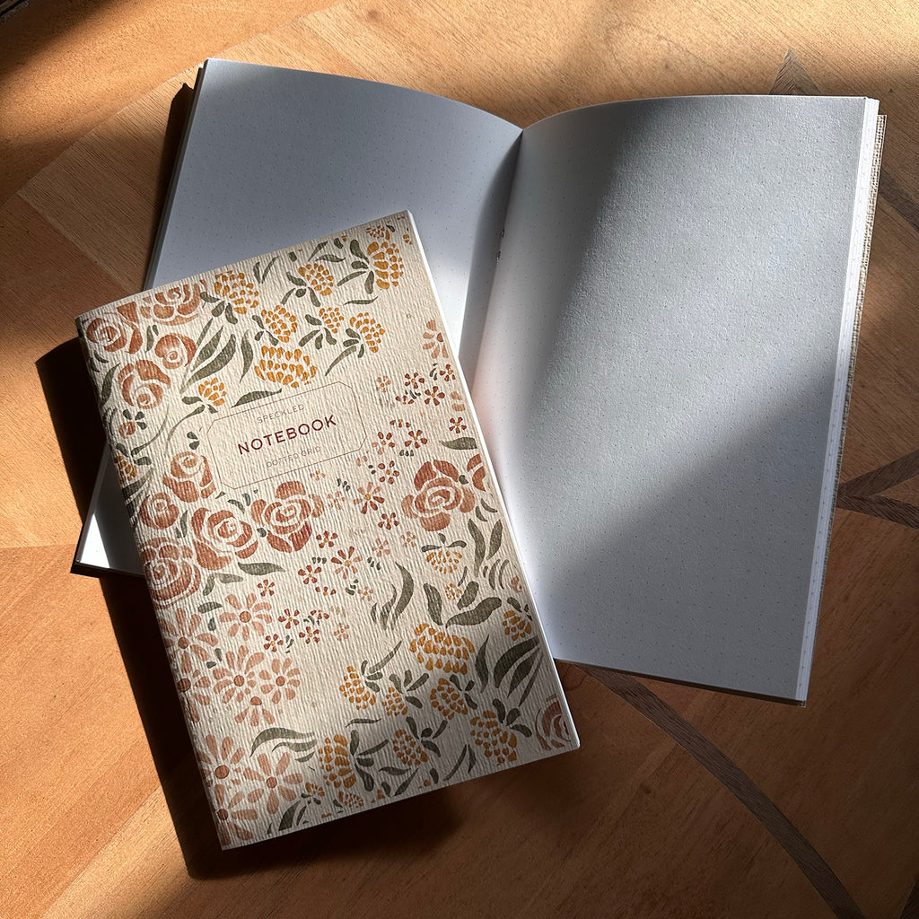 Notebook with floral pattern on wood surface.