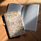 Notebook with floral pattern on wood surface.