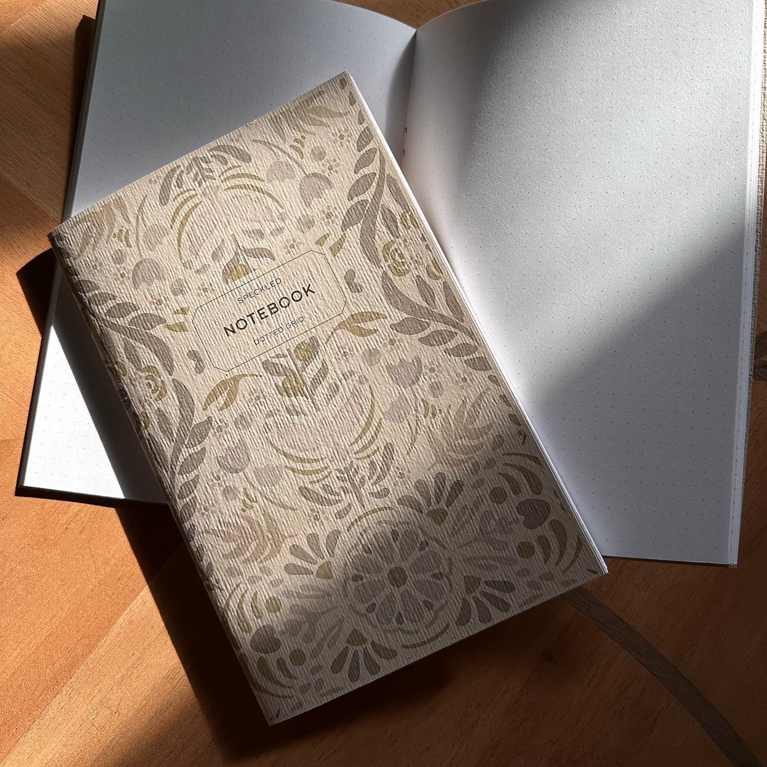 Decorative notebook with floral pattern on a wooden surface