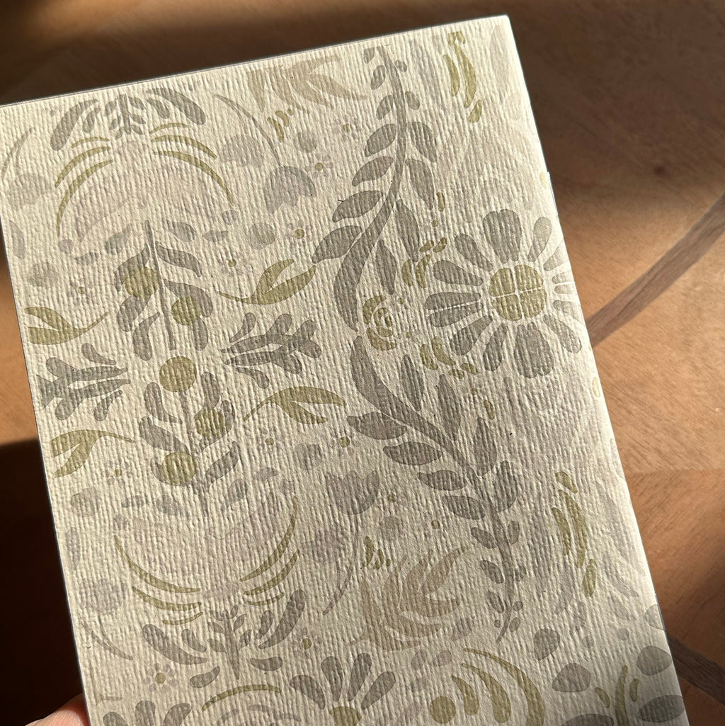 Notebook back with floral pattern on a wooden surface