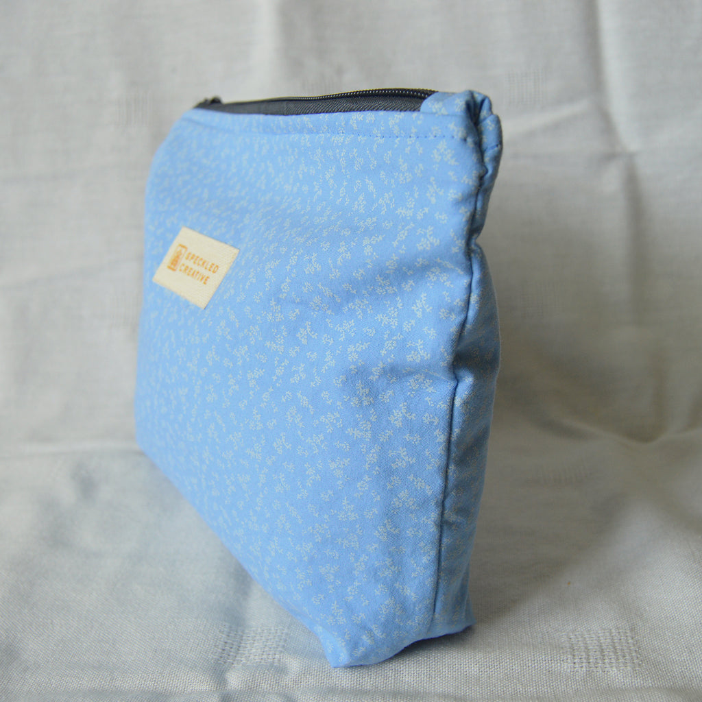 Blue pouch with a floral pattern on a light gray background