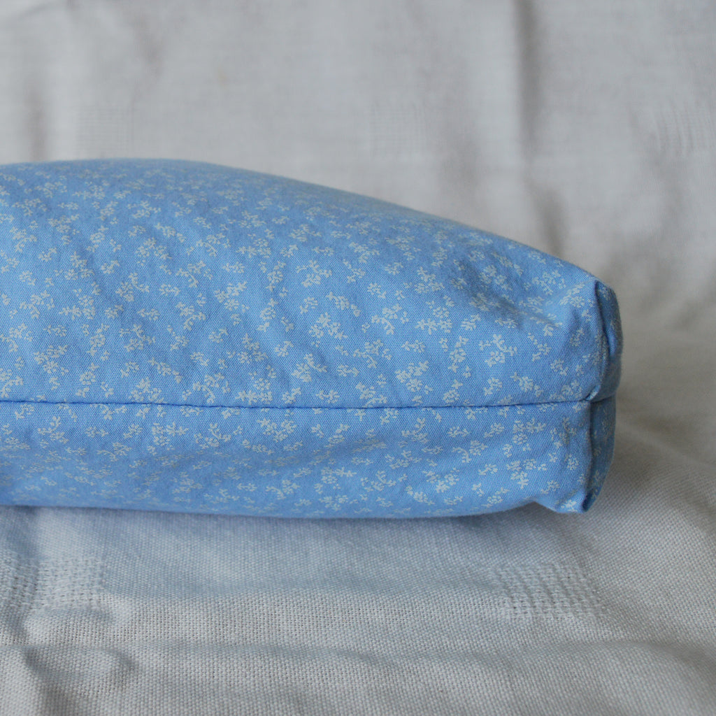 Bottom of a blue fabric pouch with a subtle pattern