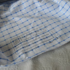 Close-up of a stamped label on product lining with blue grid pattern