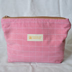 Pink checkered pouch with a gold zipper and 'Speckled Creative' label on a white background