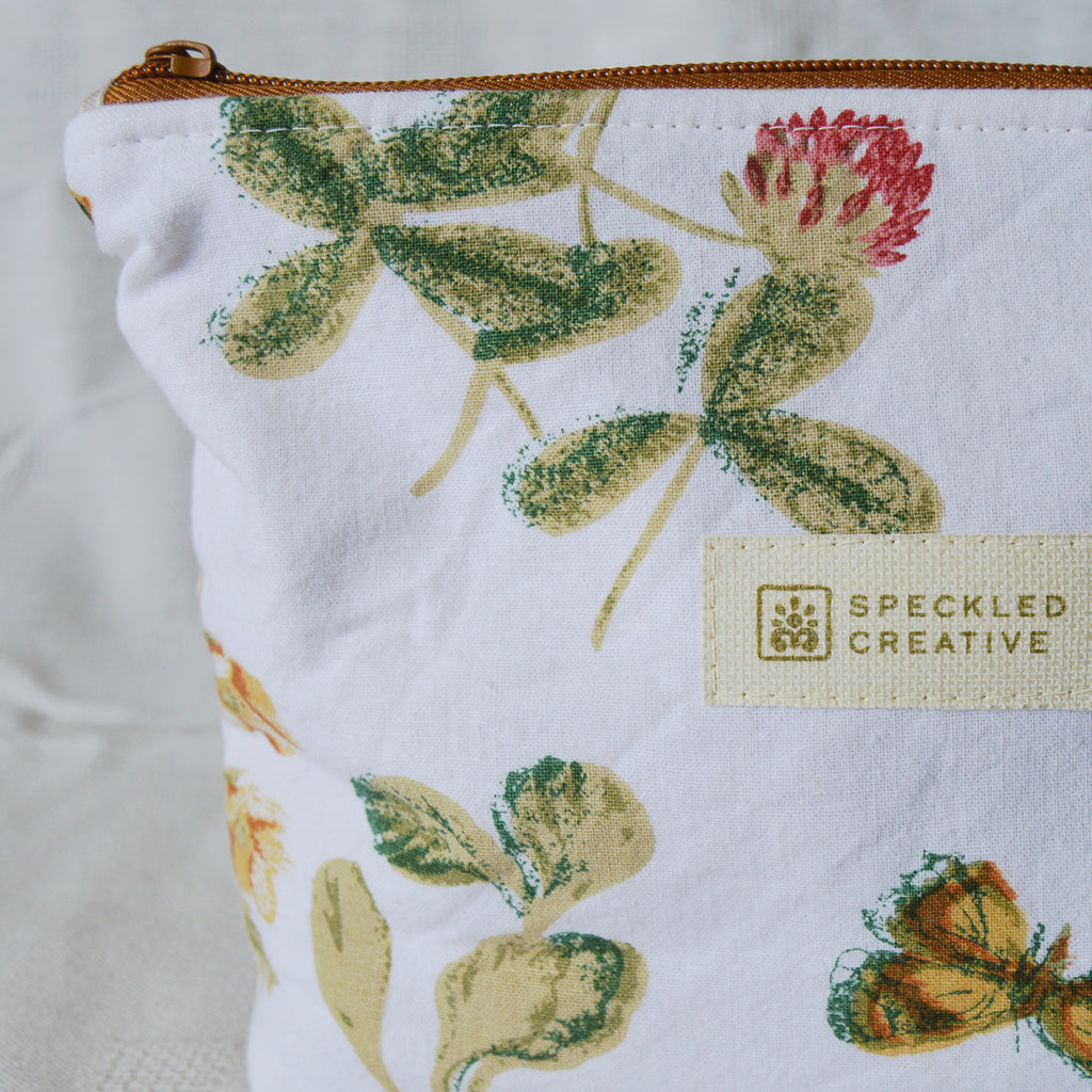 Fabric pouch with floral design and Speckled Creative label on a white background