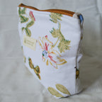 Fabric pouch with floral and nature-themed design on a light background