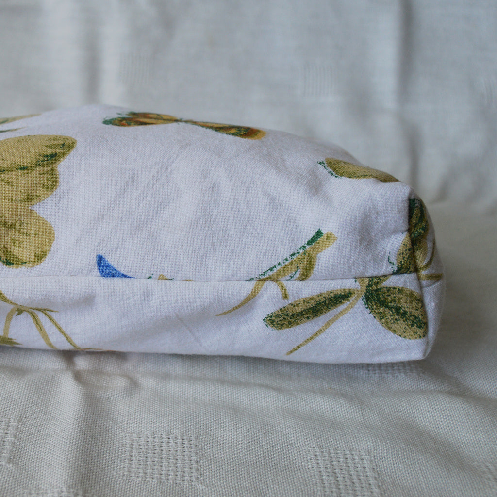 Bottom of a pouch with with green leaf pattern on a textured surface
