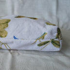 Bottom of a pouch with with green leaf pattern on a textured surface